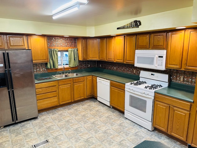 kitchen with decorative backsplash, sink, and white appliances