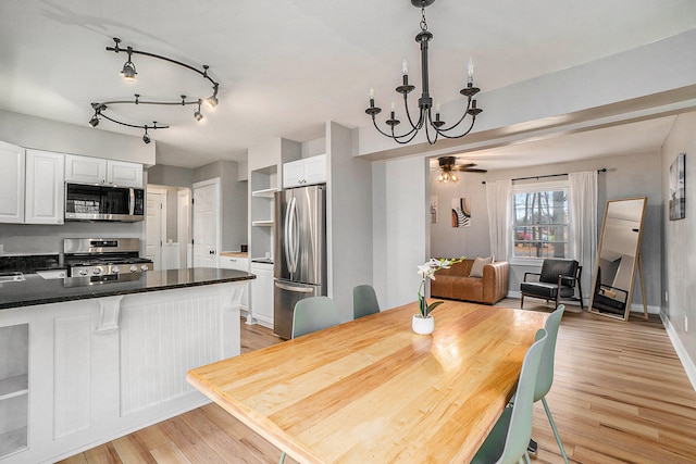 dining area featuring light hardwood / wood-style floors and ceiling fan with notable chandelier