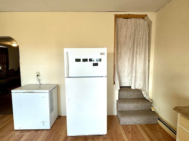 kitchen with white fridge, refrigerator, light hardwood / wood-style flooring, and a baseboard radiator