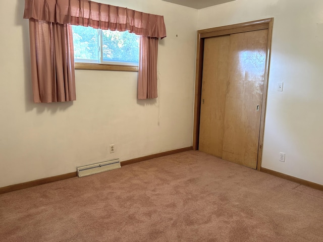 unfurnished bedroom with light carpet and baseboard heating