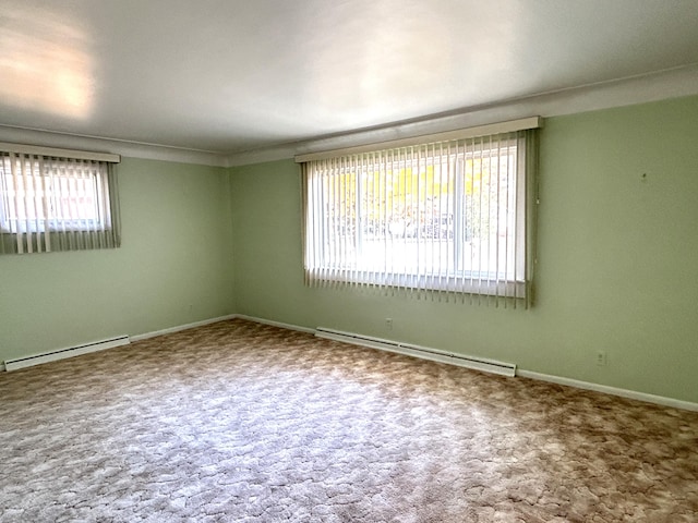 empty room featuring baseboard heating and carpet