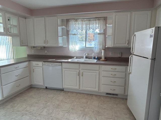 kitchen with white appliances, sink, and white cabinets