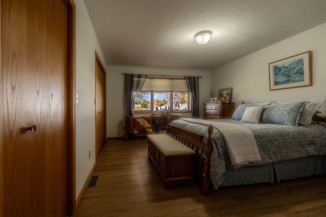 bedroom with dark hardwood / wood-style floors