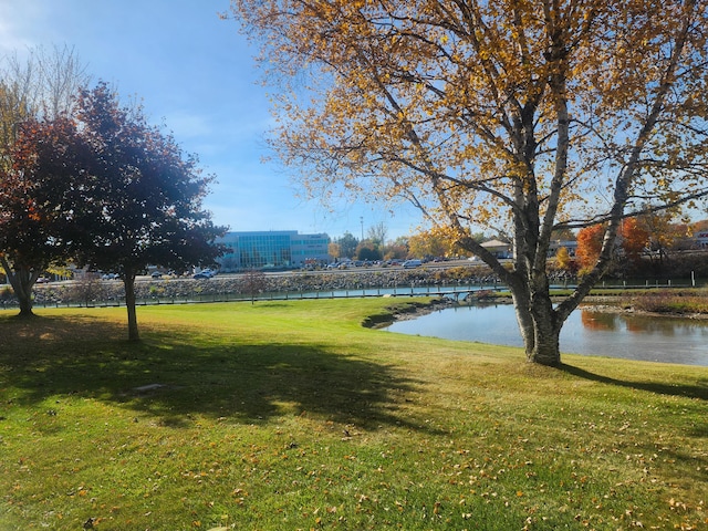 surrounding community featuring a lawn and a water view