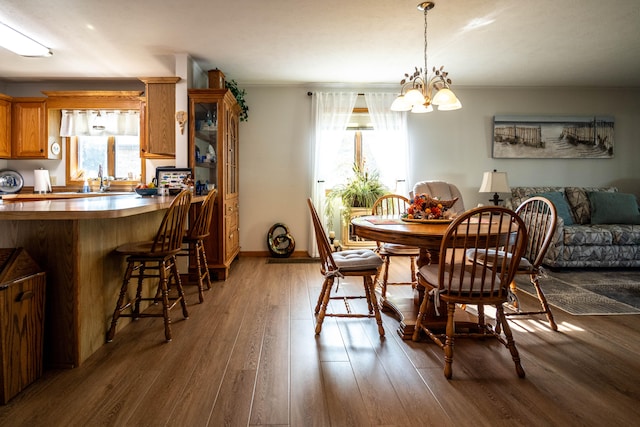 dining room featuring dark wood-type flooring, a notable chandelier, and plenty of natural light