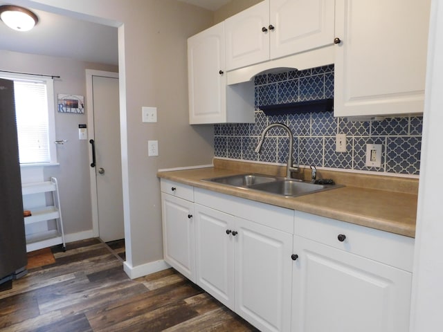 kitchen with backsplash, dark hardwood / wood-style flooring, sink, and white cabinets