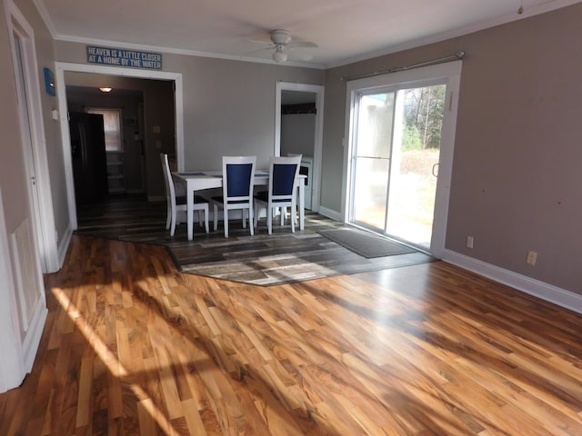 unfurnished dining area featuring wood-type flooring, ceiling fan, and crown molding