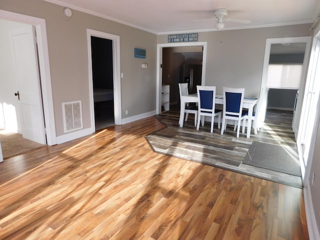 dining space featuring hardwood / wood-style flooring, ceiling fan, and crown molding