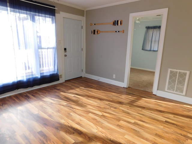 foyer with hardwood / wood-style flooring, ceiling fan, and crown molding