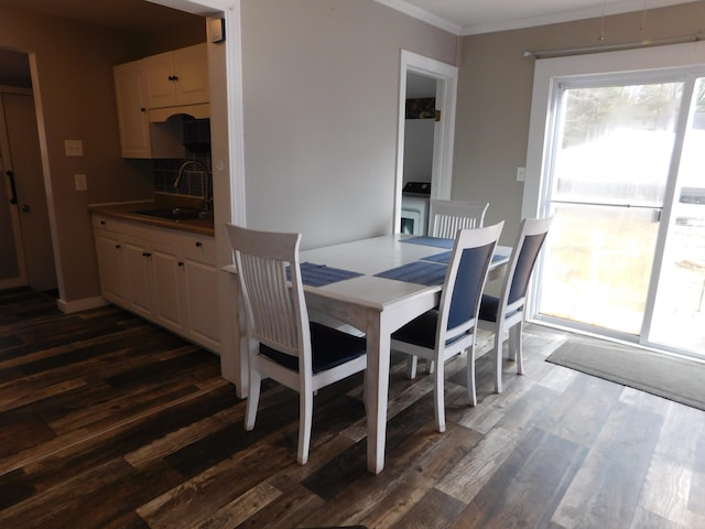 dining area with ornamental molding, dark wood-type flooring, and sink