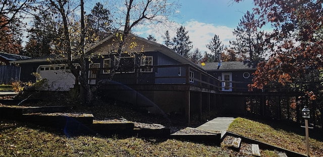 rear view of house with a wooden deck and a garage