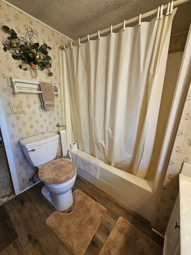 full bathroom with wood-type flooring, a textured ceiling, toilet, vanity, and shower / tub combo with curtain