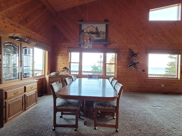 carpeted dining room with wood ceiling, wood walls, a water view, and vaulted ceiling