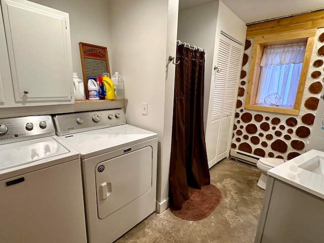 washroom featuring wood walls, baseboard heating, and washer and clothes dryer