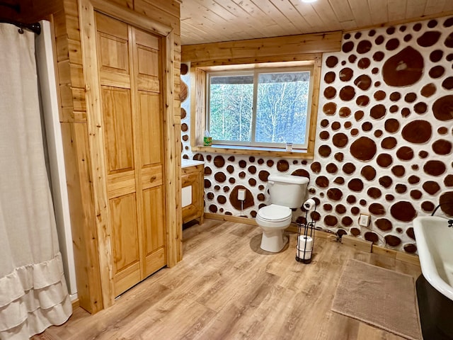 bathroom featuring toilet, wooden ceiling, hardwood / wood-style floors, a shower with shower curtain, and wood walls