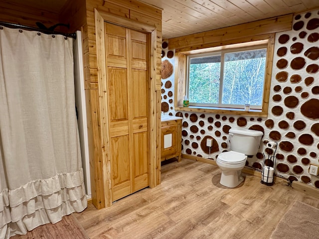 bathroom featuring wood walls, wood-type flooring, toilet, and wooden ceiling