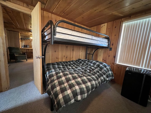 carpeted bedroom featuring wood ceiling and wood walls