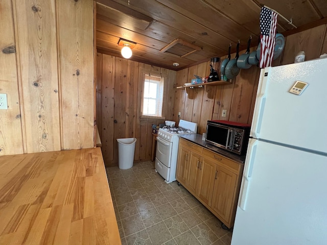 kitchen with wooden walls, white appliances, and wooden ceiling