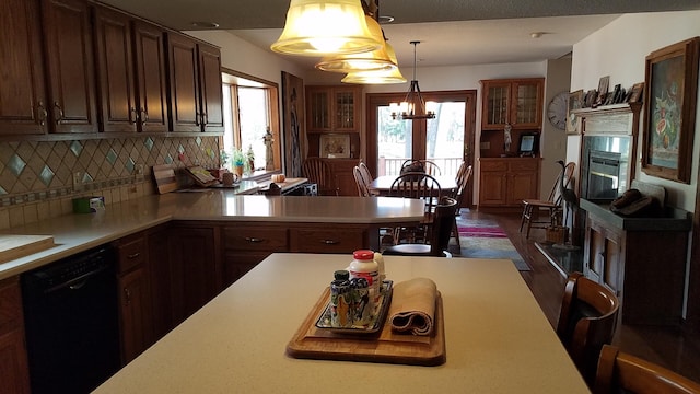 kitchen with tasteful backsplash, glass insert cabinets, light countertops, and dishwasher