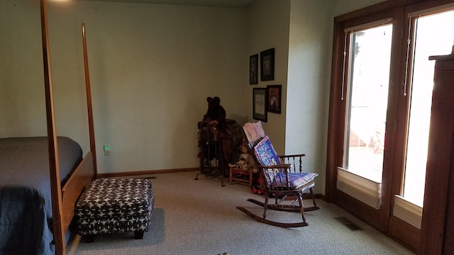 living area featuring carpet flooring, visible vents, and baseboards