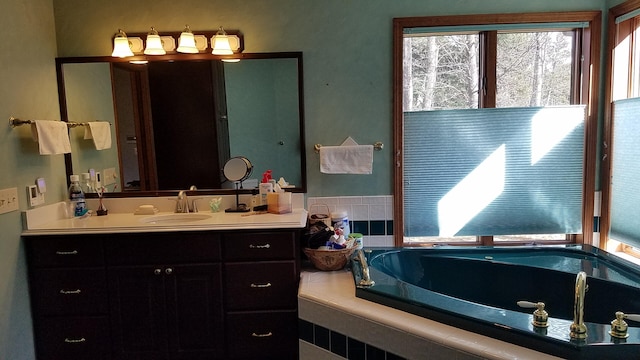 full bathroom with a garden tub, vanity, and a wealth of natural light