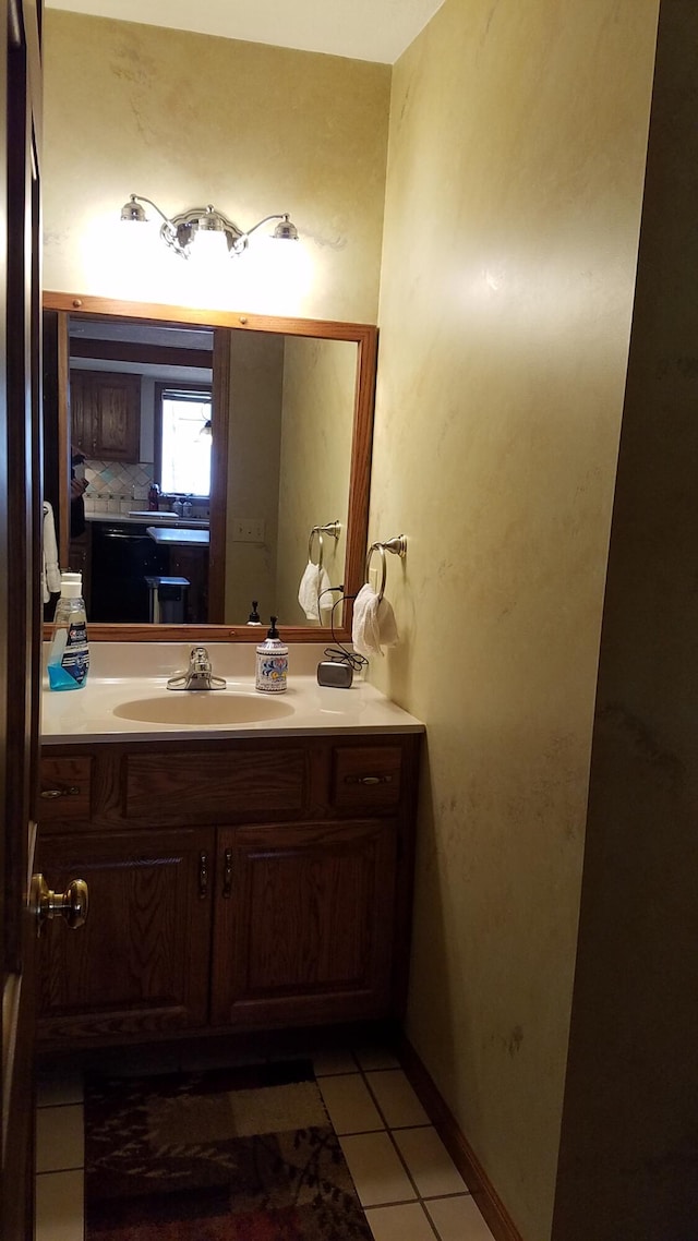 bathroom with baseboards, vanity, and tile patterned floors