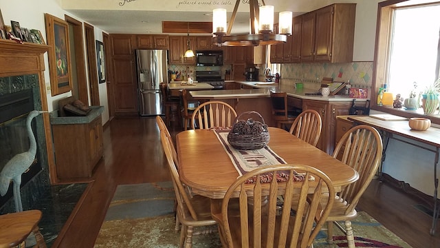 dining space featuring dark wood-style floors and a high end fireplace