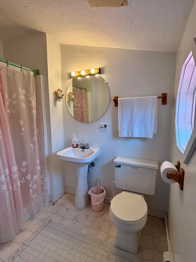 bathroom featuring toilet and a textured ceiling