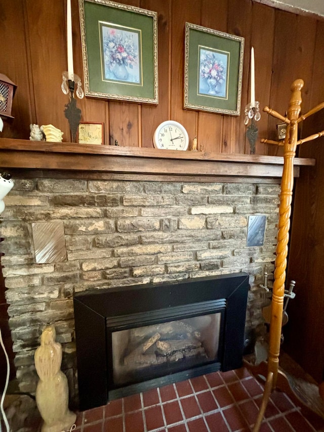 interior details featuring wooden walls and a stone fireplace