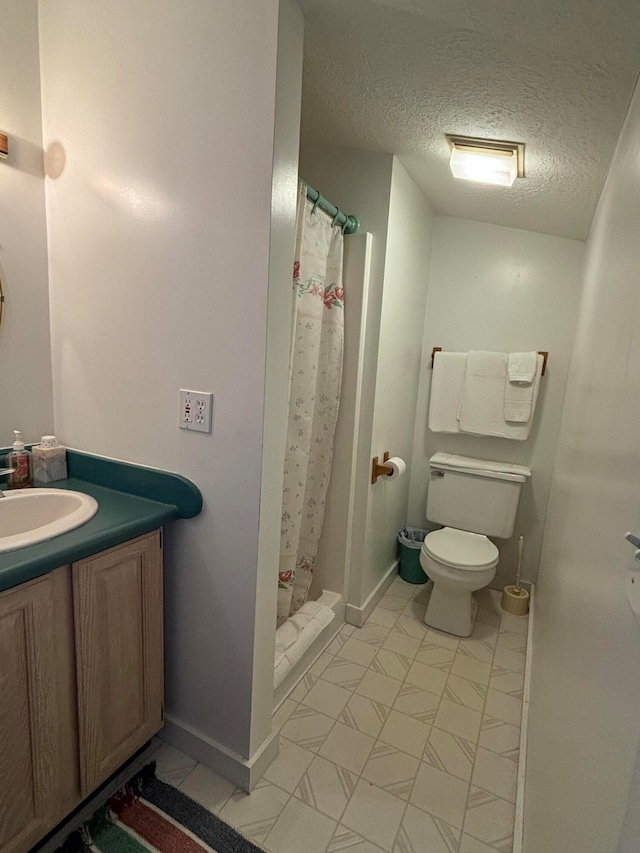 bathroom featuring vanity, toilet, a textured ceiling, and a shower with curtain