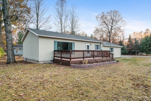 back of house with a deck and a lawn