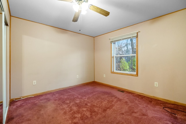 carpeted spare room with ceiling fan