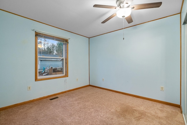 empty room with ornamental molding, light carpet, and ceiling fan