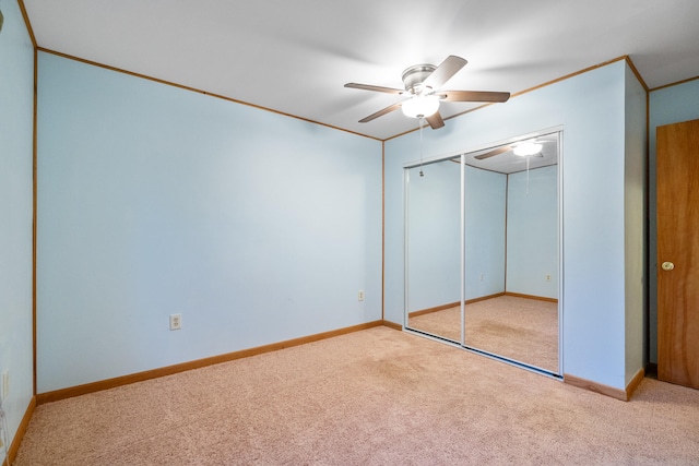 unfurnished bedroom with light colored carpet, a closet, and ceiling fan