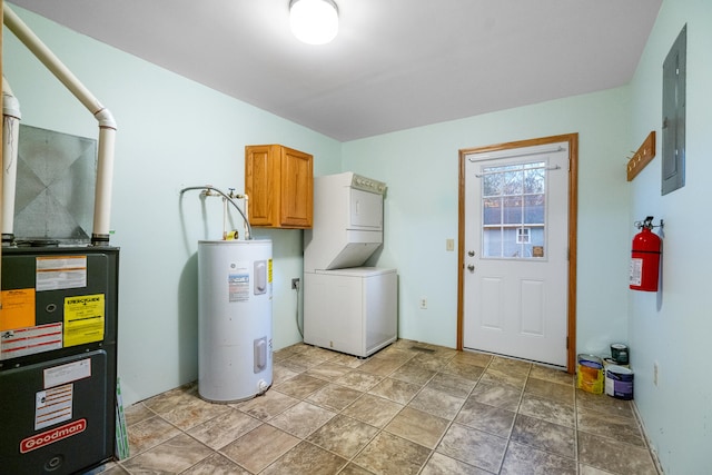 laundry room featuring electric panel, electric water heater, cabinets, and stacked washer and clothes dryer