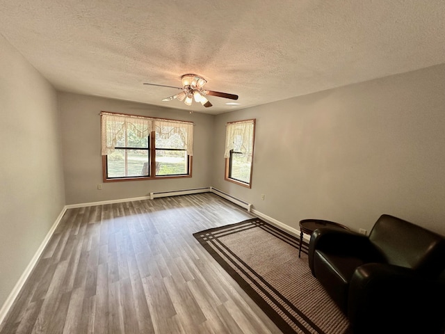 unfurnished room with hardwood / wood-style floors, ceiling fan, and a textured ceiling