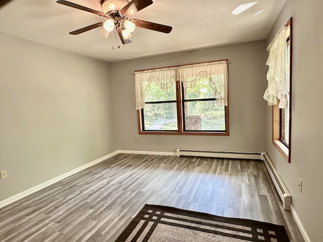 empty room featuring hardwood / wood-style floors, ceiling fan, and a baseboard radiator