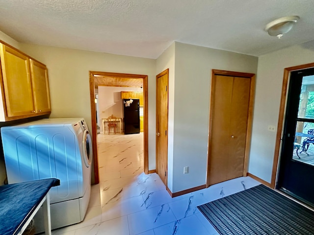 laundry room with cabinets, washing machine and dryer, and a textured ceiling