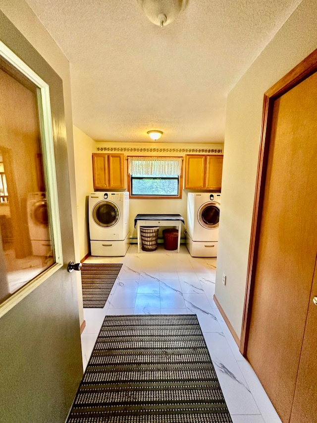 laundry room featuring washer / clothes dryer, cabinets, and a textured ceiling