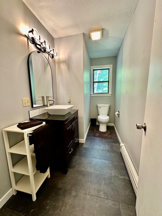 bathroom featuring toilet, vanity, a textured ceiling, and a baseboard radiator