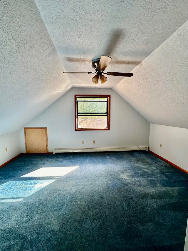 additional living space featuring ceiling fan, a textured ceiling, dark colored carpet, and lofted ceiling