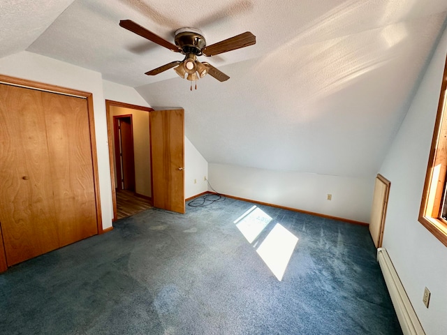 bonus room featuring ceiling fan, a baseboard radiator, a textured ceiling, and lofted ceiling