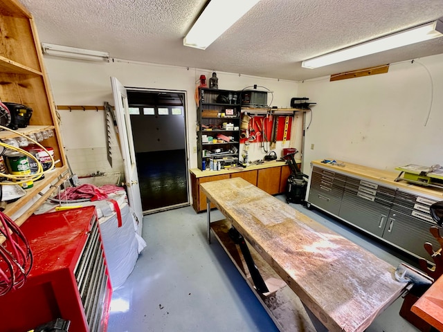 interior space with a workshop area, concrete floors, and a textured ceiling