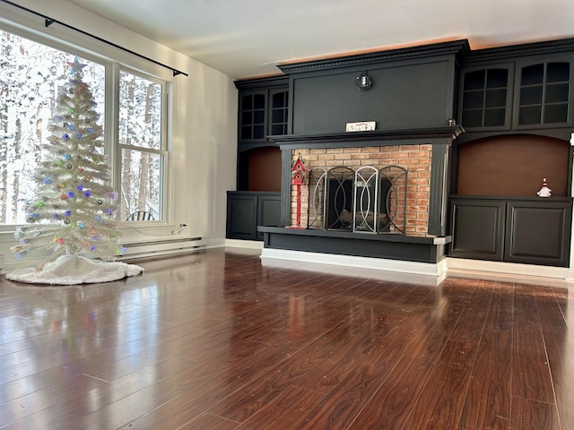 unfurnished living room featuring hardwood / wood-style floors, a fireplace, and a baseboard radiator