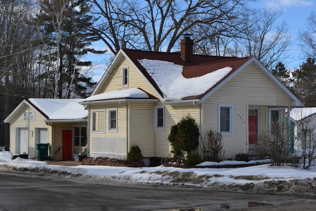 view of front of property with an attached garage and a chimney