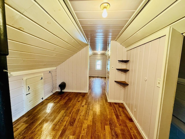 additional living space with dark wood-type flooring, wooden ceiling, vaulted ceiling, and wooden walls