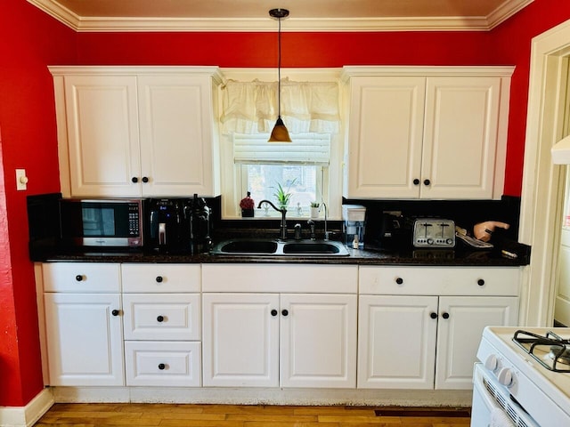 kitchen with gas range gas stove, a sink, and white cabinets