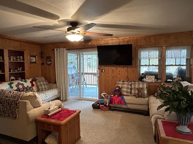 carpeted living room with wooden walls, a textured ceiling, and ceiling fan