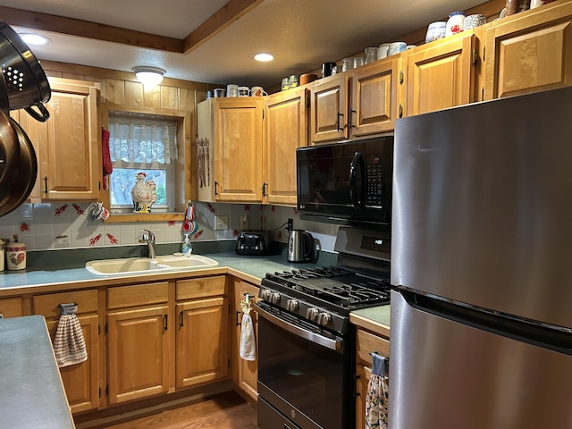 kitchen featuring light hardwood / wood-style floors, stainless steel appliances, sink, and decorative backsplash