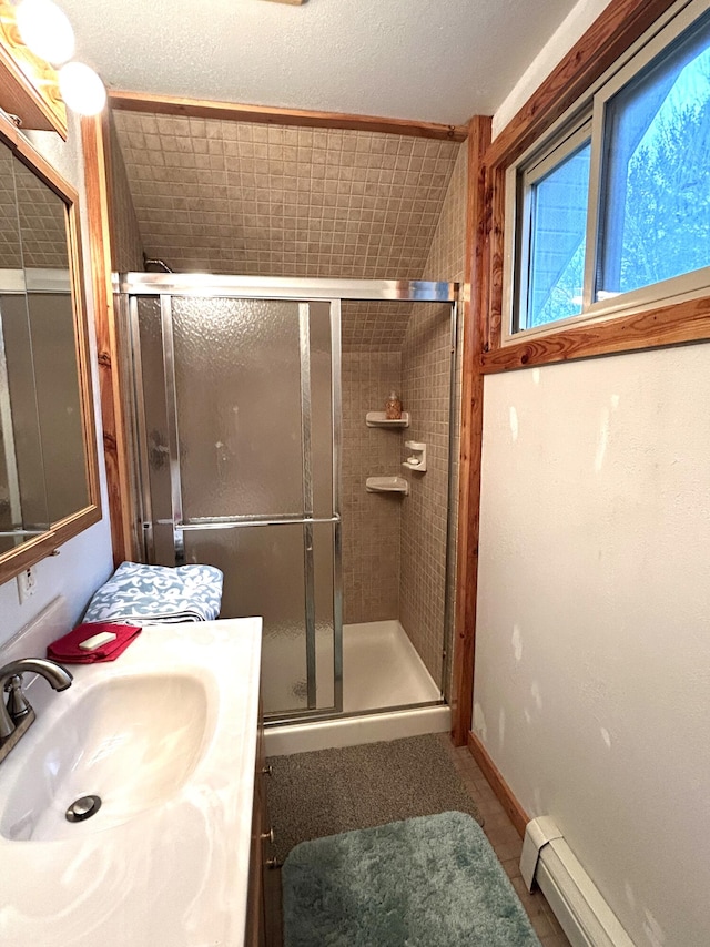 bathroom featuring a shower with door, vanity, and a baseboard heating unit